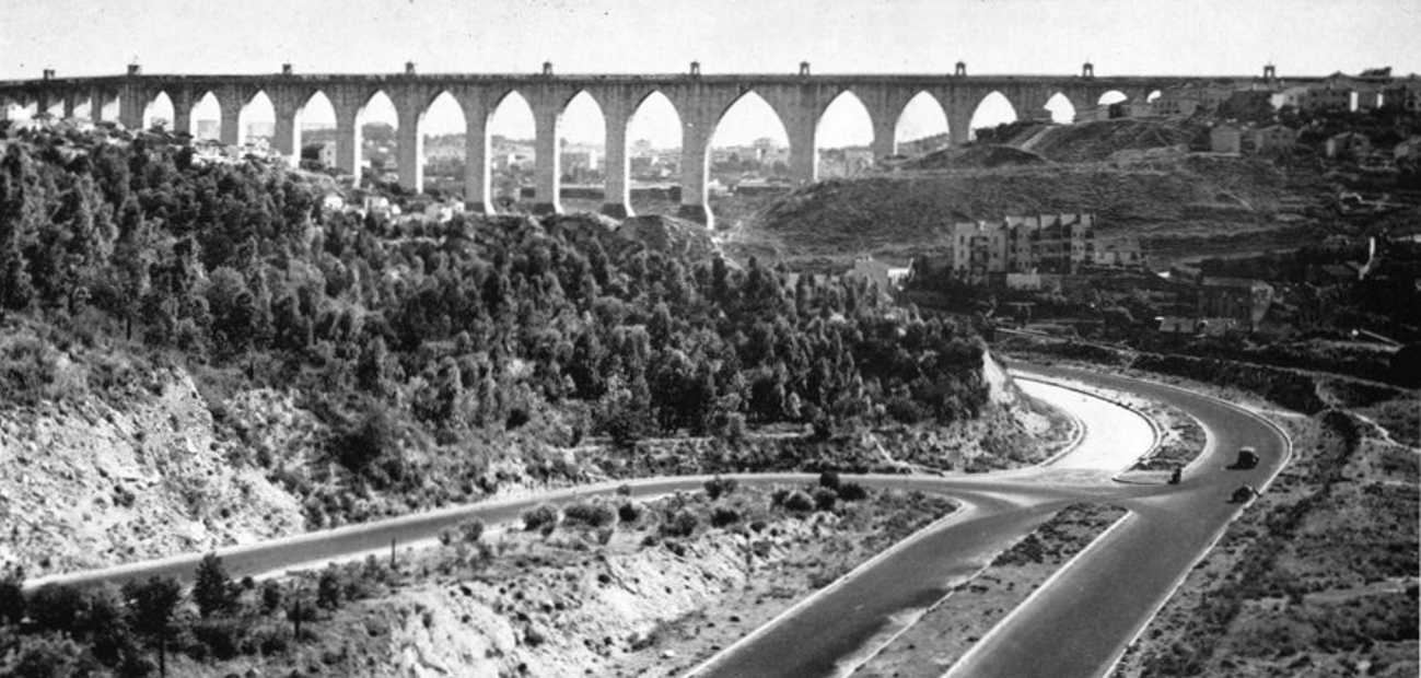 The stone arches of the Águas Livres aqueduct crossing a Lisbon valley
